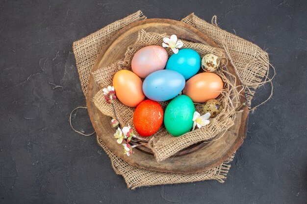 vista dall'alto uova di Pasqua colorate all'interno del piatto su superficie scura