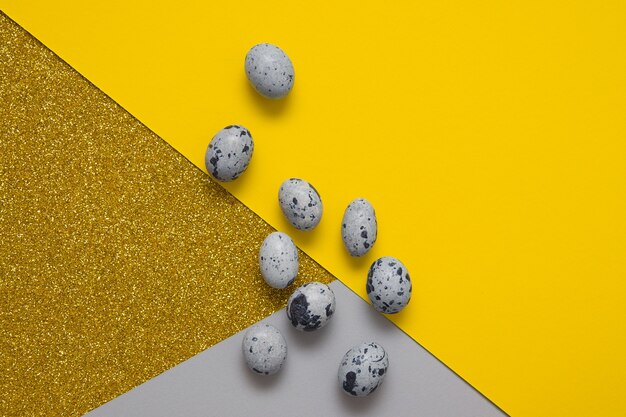 Vista dall'alto uova di Pasqua grigie e sfondi di carta colori giallo-grigi