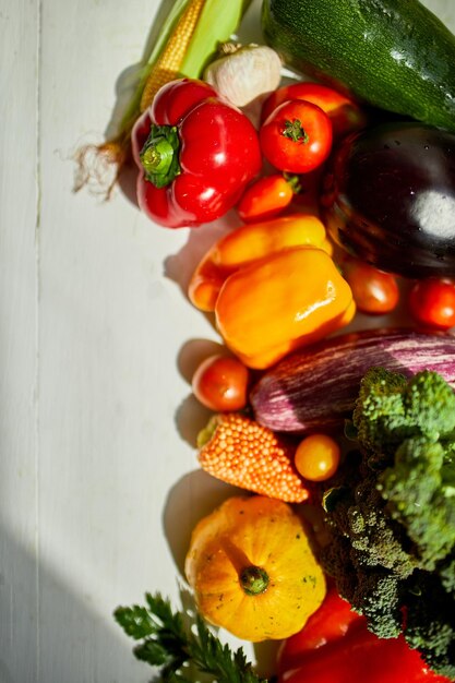 Vista dall'alto verdure fresche biologiche assortite sul tavolo in cucina alla luce del sole drogheria shopping sano cibo vegano piatto laico copia spazio Layout con testo libero