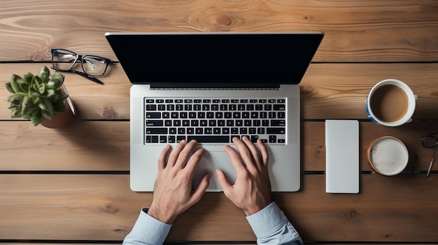 vista dall'alto verso il basso sulle mani maschili che digitano sulla tastiera sul posto di lavoro contemporaneo con computer e caffè