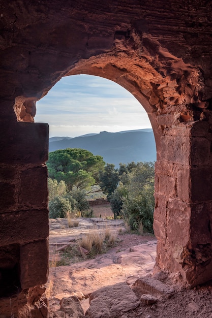 Vista dall&#39;interno di un castello in rovina sulla montagna al tramonto