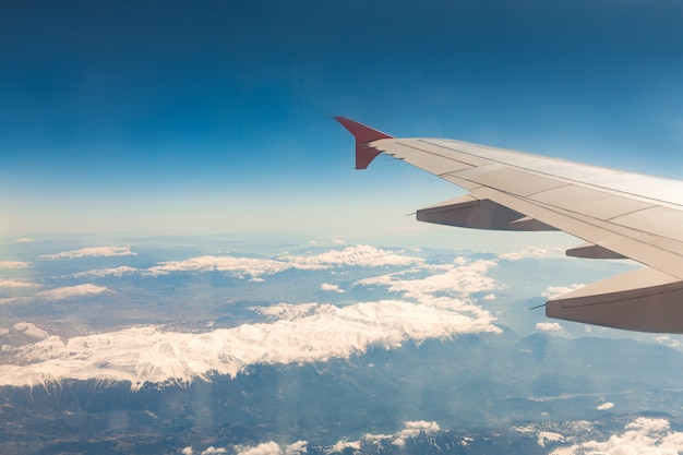 Vista dalla finestra dell'aereo che vola sopra le montagne