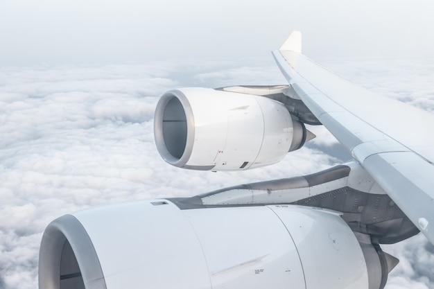 Vista dalla finestra dell'aeroplano e dall'ala, sopra le nuvole lanuginose, il concetto di volo e di viaggio