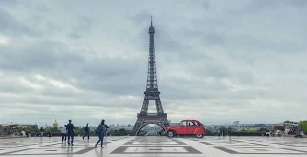 Vista dalla piazza del Trocadero (Place du Trocadero) alla torre eiffel con auto rossa d'epoca a parigi. ideale per layout di siti web e riviste