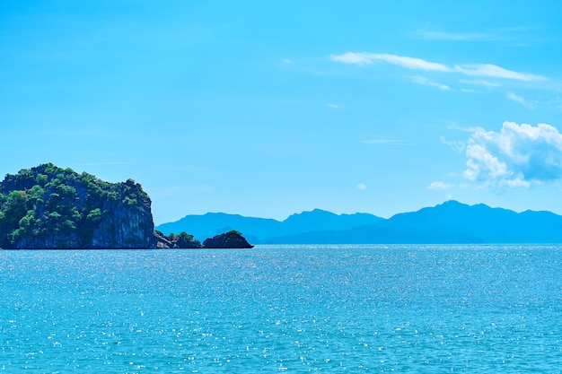 Vista dalla spiaggia alle rocce nell'oceano lontano dalla costa. Paesaggio naturale di una spiaggia tropicale