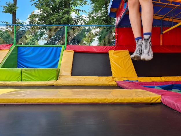 Vista dei piedi di un ragazzo in calzini a righe che salta sul trampolino praticando acrobazie