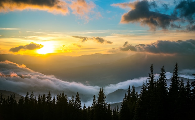 Vista del bel tramonto nella valle di montagna. Colline circondate da nuvole con cielo drammatico sullo sfondo. Concetto di bellezza della natura e tramonto.