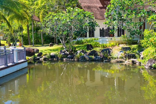 Vista del bellissimo laghetto verde e degli edifici dell'hotel di lusso al resort tropicale