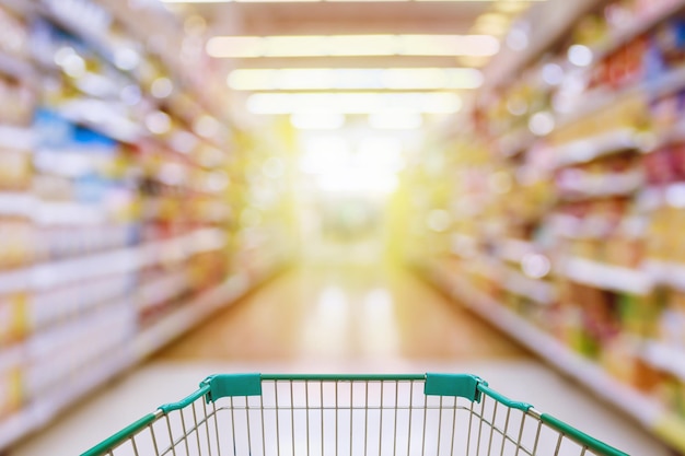 Vista del carrello nel corridoio del supermercato sfocato sfondo sfocato