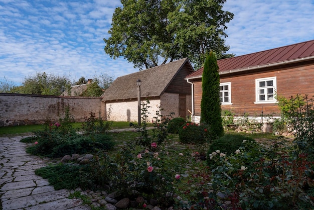 Vista del cortile di una tradizionale tenuta mercantile sulla strada principale di Izborsk Pechorskaya Street in una giornata nuvolosa estiva Izborsk Pskov regione Russia