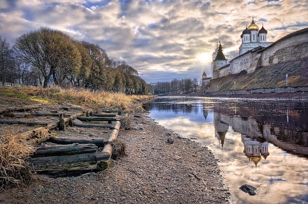 Vista del Cremlino di Pskov con riflesso nell'acqua del fiume Pskova e dei resti