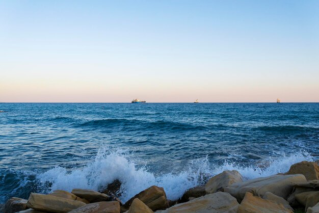 Vista del Mar Mediterraneo con tre navi all'orizzonte da un sentiero sul mare di Limassol