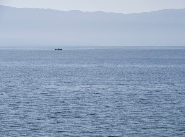 Vista del mare al tramonto e del pescatore nel Mar Egeo sull'isola di Evia Grecia