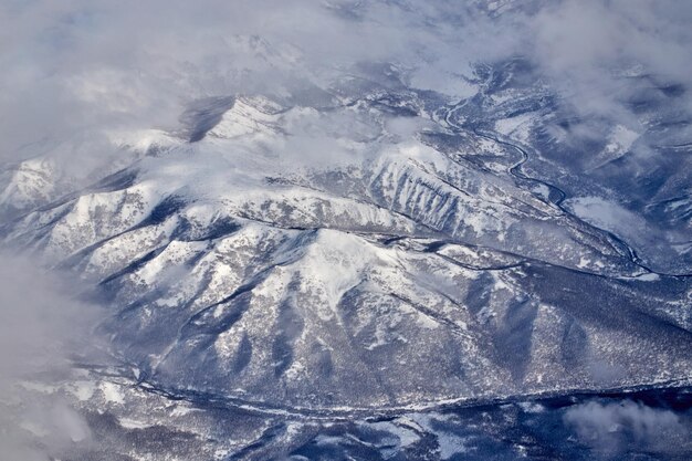 Vista del paesaggio di montagna da un aeroplano Panorama innevato