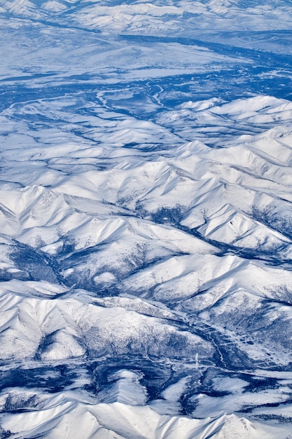 Vista del paesaggio di montagna da un aeroplano Panorama innevato