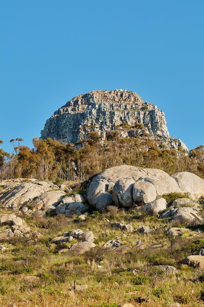 Vista del paesaggio e cielo blu con copia spazio della montagna di Lions Head a Città del Capo in Sud Africa Ripido e panoramico famoso terreno per escursioni e trekking con alberi, cespugli, arbusti ed erba che cresce intorno ad esso