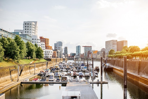 Vista del paesaggio urbano al tramonto sul moderno quartiere del porto dei media con splendidi edifici e barche nella città di Dusseldorf in Germania