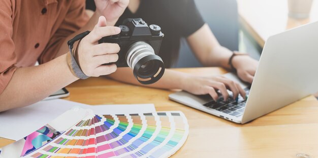 Vista del primo piano del grafico professionista che mostra la macchina fotografica al suo collega