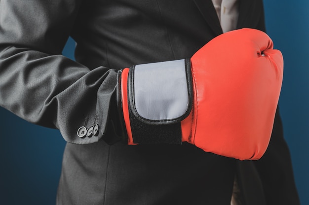 Vista del primo piano dell'uomo d'affari che porta guantoni da boxe rossi