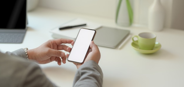 Vista del primo piano dell'uomo d'affari professionale che tiene lo smartphone dello schermo in bianco