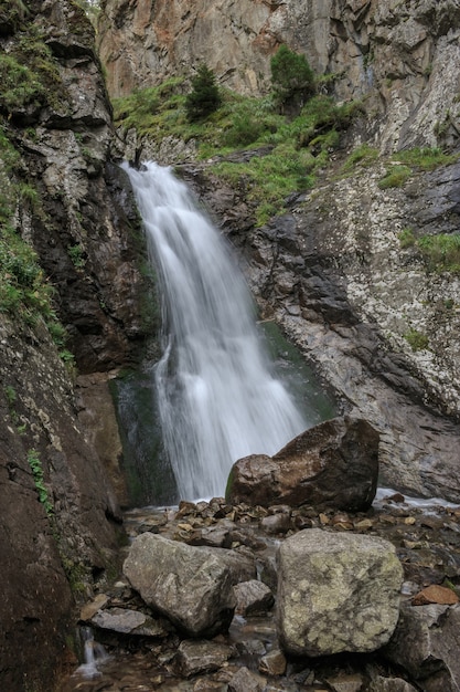 Vista del primo piano delle scene della cascata in montagne, parco nazionale Dombay, Caucaso, Russia, Europa. Paesaggio estivo e giornata di sole