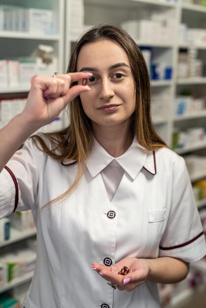 Vista del primo piano di una ragazza del farmacista che tiene piccole pillole