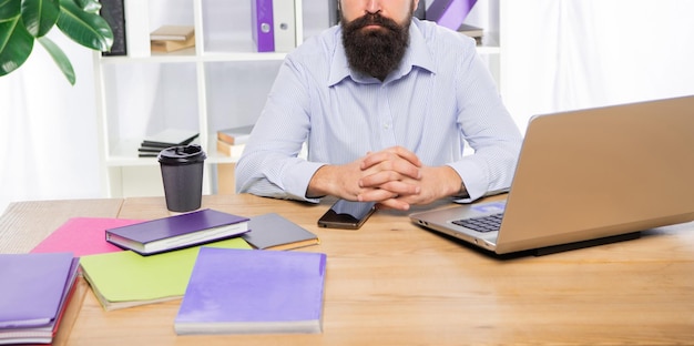 Vista del raccolto professionale dell'uomo che lavora al posto di lavoro della scrivania dell'ufficio