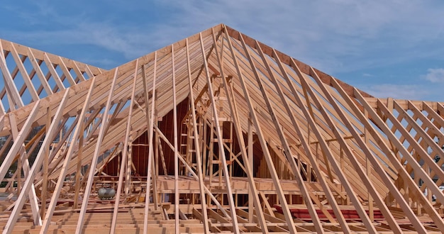 Vista del sistema di travi reticolari del tetto casa con struttura in legno in costruzione