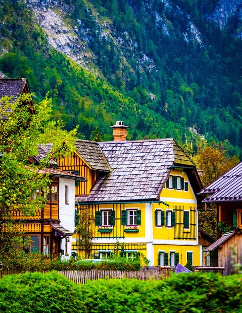 Vista del vecchio edificio giallo brillante sullo sfondo di un'alta montagna rocciosa a hallstatt austria