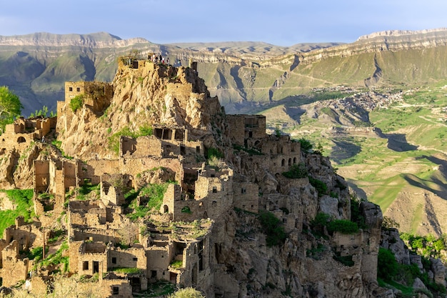 Vista del villaggio disabitato di Gamsutl sulla cima di una montagna in Daghestan, il villaggio abitato di Chokh è visibile in lontananza