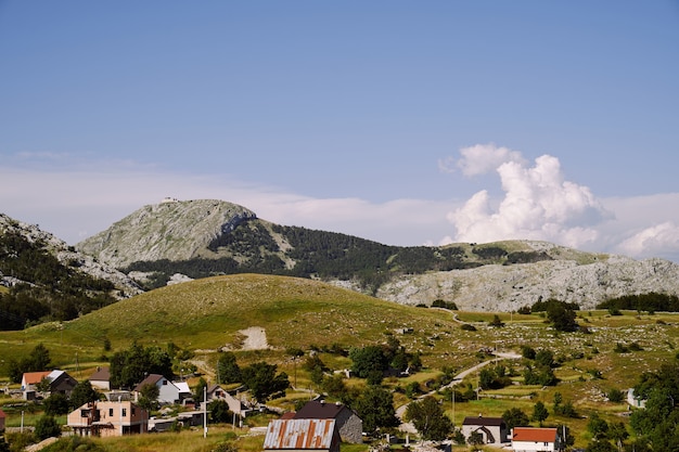 Vista del villaggio in montagna sullo sfondo del cielo e del verde