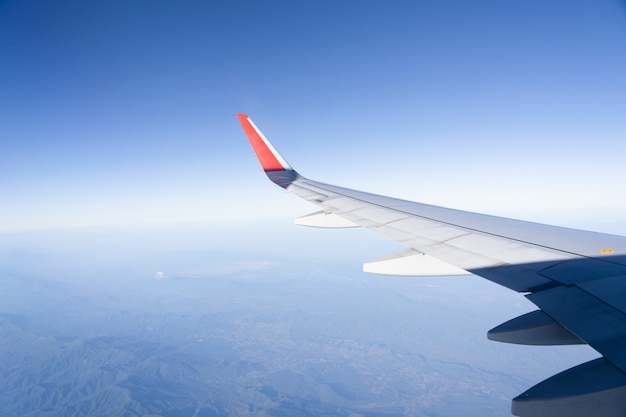 Vista dell'aereo dell'ala con paesaggio del cielo blu