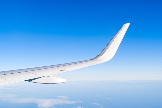 Vista dell'ala dell'aeroplano attraverso la finestra nel cielo nuvole cielo ala degli aeroplani attraverso l'oblò del velivolo