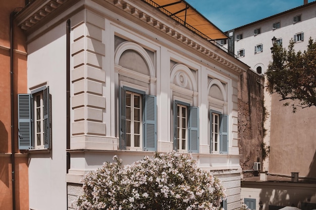 Vista dell'angolo di un imponente antico edificio bianco ristrutturato con persiane a finestra turchese e