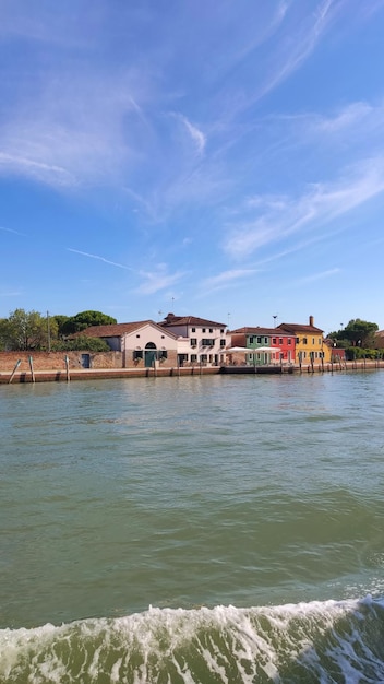 Vista dell'argine del Canale di Venezia in una calda giornata estiva, con barche galleggianti e vecchie case, Venezia