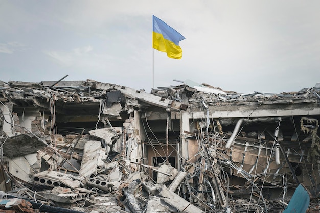 Vista dell'edificio distrutto delle rovine del relitto dell'edificio e della bandiera ucraina