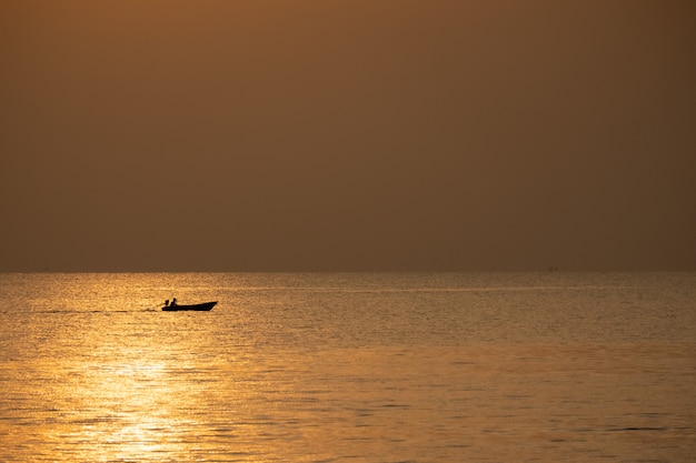 Vista della barca che galleggia sopra il mare con alba