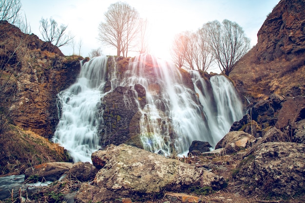 Vista della bella cascata di montagna con cielo blu su sfondo