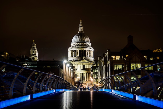 Vista della cattedrale di Saint Paul dalle luci blu del Millenium Bridge di notte a Londra