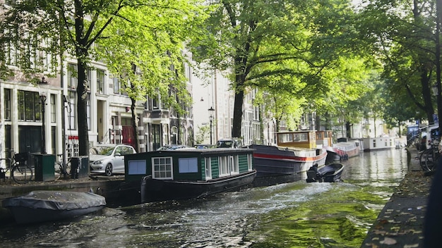 Vista della città di Amsterdam: mattina presto, giornata nuvolosa, autunno - auto e biciclette parcheggiate lungo il canale - Paesi Bassi, grandangolo