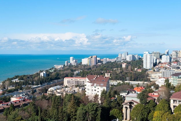 Vista della città di Sochi in una soleggiata giornata invernale con cielo blu brillante con nuvole bianche e mare blu Sfondo della natura con messa a fuoco selettiva Concetto di viaggio