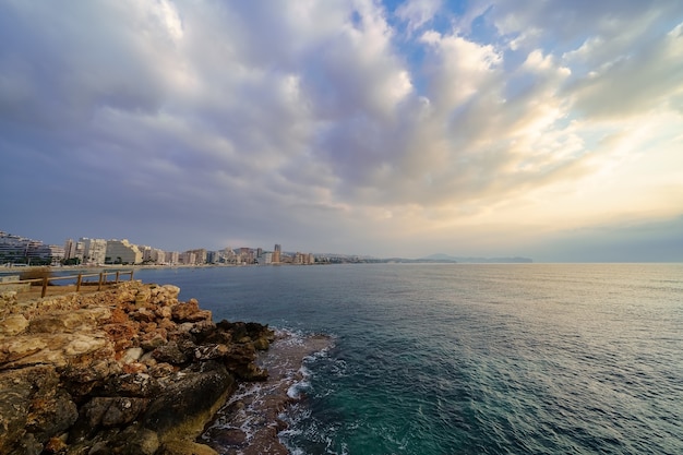 Vista della città estiva sul mare su un tramonto dorato con nuvole mozzafiato.