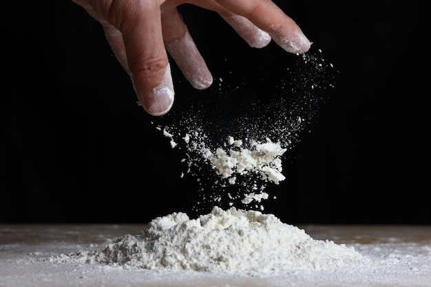 Vista della cucina con farina che cade sul tavolo per fare la pasta