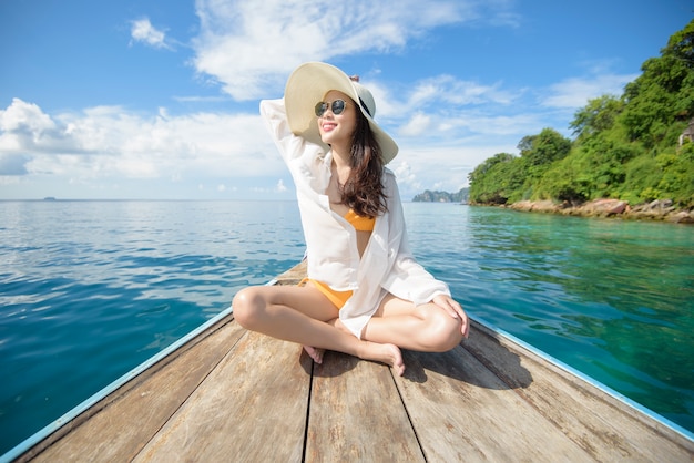 Vista della donna in costume da bagno godendo sulla barca longtail tradizionale tailandese sulla bellissima montagna e sull'oceano, le isole Phi Phi, Thailandia