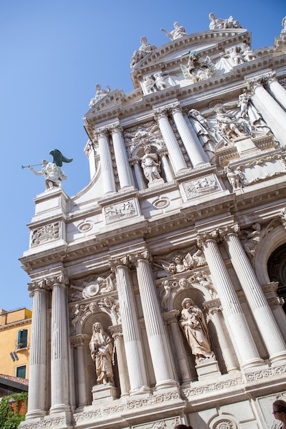 Vista della facciata antiquata della cattedrale storica del palazzo a Venezia, Italia su un fondo del cielo blu.