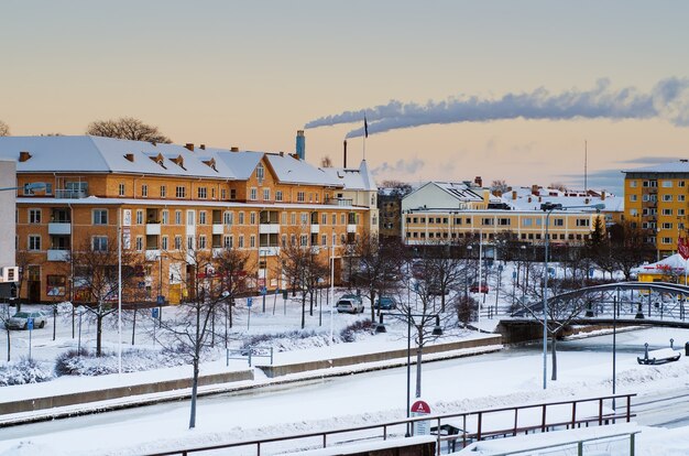 Vista della piccola città europea svedese Soderhamn all'alba con fumo dai tubi dell'impianto, concetto ambientale industriale