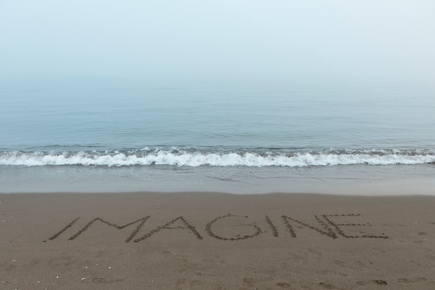 Vista della sabbia della spiaggia in estate con un messaggio scritto su di essa