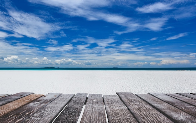 Vista della spiaggia di sabbia bianca e tavola di legno