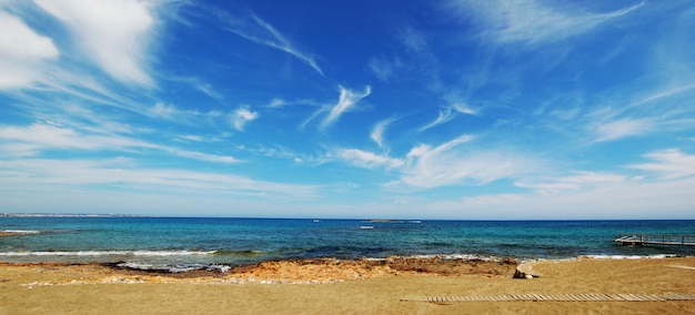 Vista della spiaggia sabbiosa del mare. nuvole bianche