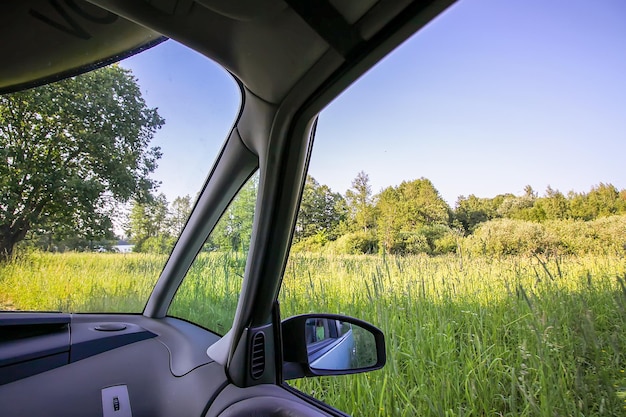 Vista della strada di campagna forestale attraverso il vetro dell'auto durante il viaggio